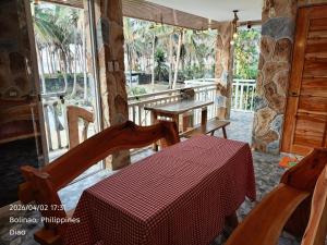 a dining room with a table and chairs on a porch at Ocean View and Beach Access Rustic Stone House in Bolinao