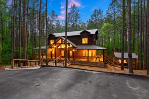 a house in the middle of the forest at Low Rider Lodge - Backs to Pine Forest and ATV Trail Access from Driveway in Broken Bow