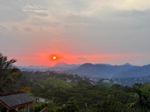 a sunset over a city with mountains in the background at Bethel Rest Homestay in Kandy