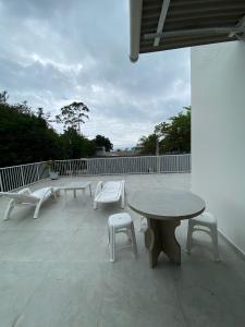 a group of benches and a table on a patio at Pousada Baia dos Golfinhos in Governador Celso Ramos
