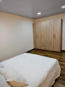 a bedroom with a bed and a wooden cabinet at Amazonía Luxury in Florencia +5 photos