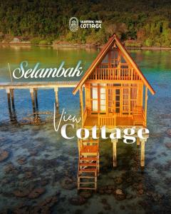 a view of a house on a dock in the water at Selambak View Cottage in Pulau Siantan