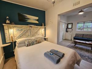 a bedroom with a large bed with two towels on it at Heide Cottage in Struisbaai