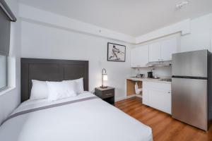 a bedroom with a white bed and a kitchen at Varsity West in Centralia
