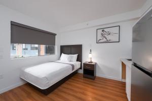 a white bedroom with a bed and a window at Varsity West in Centralia