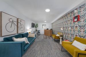 a living room with a blue couch and yellow chairs at Varsity West in Centralia
