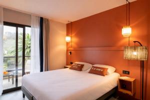 a bedroom with a large bed and a large window at Résidence Pierre & Vacances L'Archipel in Perros-Guirec