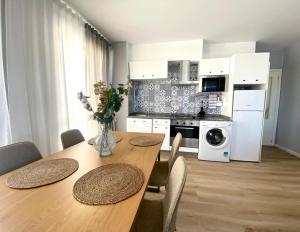 a kitchen with a wooden table with chairs and a dining room at Apartamento A pie de Playa in Miño