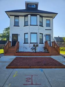 a large white house with a large front porch at Midtown Detroit Upper Retreat in Detroit