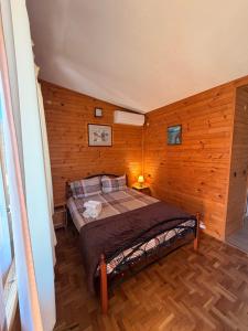 a bedroom with a bed in a room with wooden walls at Guest House „ Mountain Rest“ in Lilyanovo +32 photos