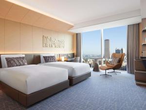 a hotel room with two beds and a large window at Fairmont Ambassador Seoul in Seoul