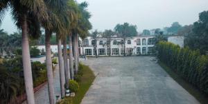 a large white building with palm trees in front of it at Vatika Hotel Pvt Ltd in Nepālganj