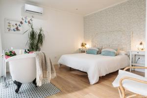 a white bedroom with a bed and a bathtub at Casa Salitre in Boiro +55 photos