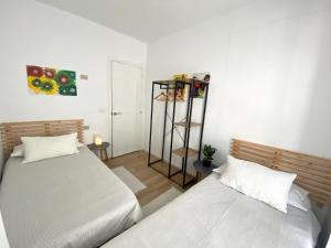 a bedroom with two beds and a book shelf at Apartamento A pie de Playa in Miño