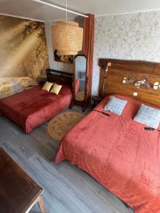 a bedroom with two beds and a table and a lamp at Gîte de Jean-Benoit in Le Passage +79 photos