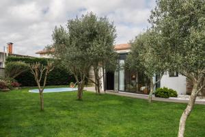 a garden with trees in front of a house at Casa Salitre in Boiro