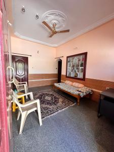 a living room with a couch and a ceiling fan at Sri Devi Krupa in Hubli