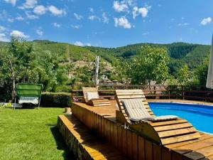 two chairs sitting on a deck next to a swimming pool at Guest House „ Mountain Rest“ in Lilyanovo
