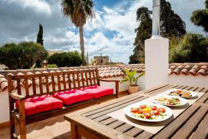 a wooden bench with two plates of food on a patio at Hotel Emblemático Duque de la Torre in Arona