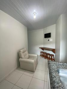 a living room with a chair and a table at Pousada Baia dos Golfinhos in Governador Celso Ramos