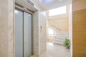 a lobby with a glass door and stairs at MGR Residency in Pondicherry