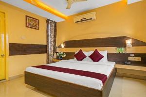 a bedroom with a large bed with red pillows at MGR Residency in Pondicherry