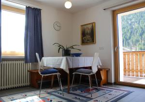 a dining room with a table and two chairs at Panorama Latemar in Nova Levante