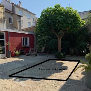 a patio with a tree and a sign that reads place point value volume at L'Atelier in Le Mans