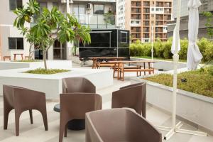a patio with a table and chairs and a piano at Loft Moderno Vista Mar - 14 Minutos De Copacabana in Rio de Janeiro