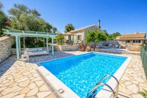 a pool with a gazebo and a house at Villa Agathi in Anemogiannátika