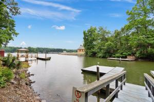 a river with a dock and a boat on it at Pool Table, Massive Balcony, Firepit, & Spacious! in Sherrills Ford