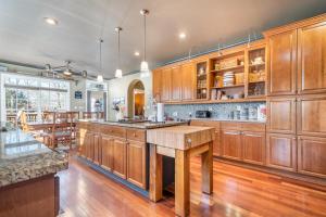 a large kitchen with wooden cabinets and a wooden table at Pool Table, Massive Balcony, Firepit, & Spacious! in Sherrills Ford