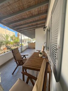 a patio with a wooden table and chairs on a balcony at Akti Rooms And Studios in Livadi