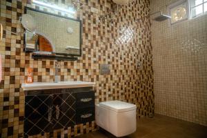 a bathroom with a toilet and a sink and a mirror at White House By Kulut in Shamshi +36 photos