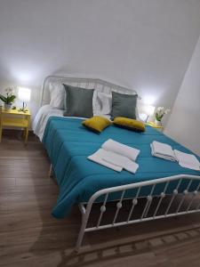 a bedroom with a bed with blue sheets and yellow pillows at NaMi in Battipaglia +2 photos