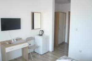 a white room with a desk and a mirror at Family Hotel PUDEV in Sunny Beach