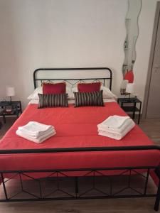 a large red bed with red sheets and pillows at NaMi in Battipaglia
