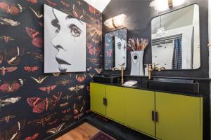 a bathroom with a green vanity and a floral wallpaper at The Disco Chalet in Steamboat Springs +37 photos