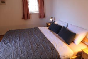 a bedroom with a large bed with two pillows at Panorama Latemar in Nova Levante