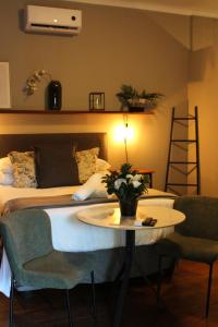 a bedroom with a bed and a table and chairs at Stay Local Potchefstroom in Potchefstroom