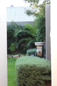 a garden with a fountain and green bushes at Stay Local Potchefstroom in Potchefstroom