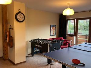 a living room with a ping pong table and a clock at Mirabelka Mucharz in Mucharz