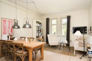 a dining room and living room with a table and chairs at Edelsminde Bed & Breakfast in Haslev
