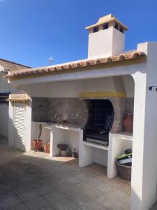 an outdoor kitchen with a pizza oven under a roof at Spacious House in Sagres with Private Patio & BBQ in Sagres