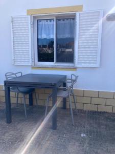 a blue table and chairs in front of a window at Spacious House in Sagres with Private Patio & BBQ in Sagres
