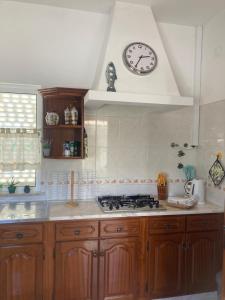 a kitchen with a clock on the wall above a stove at Spacious House in Sagres with Private Patio & BBQ in Sagres