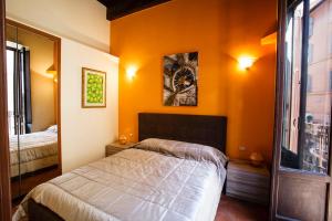 ローマにあるCrispi Apartmentのオレンジ色の壁のベッドルーム1室、ベッド1台、窓が備わります。