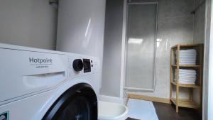 a white washing machine in a bathroom with a shower at Duplex avec vue au centre de Bussang in Bussang +51 photos
