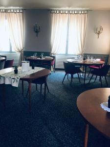 a dining room with tables and chairs and windows at Blanche de Castille in Bléneau