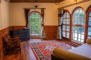 a living room with large windows and a table and chairs at White House By Kulut in Shamshi